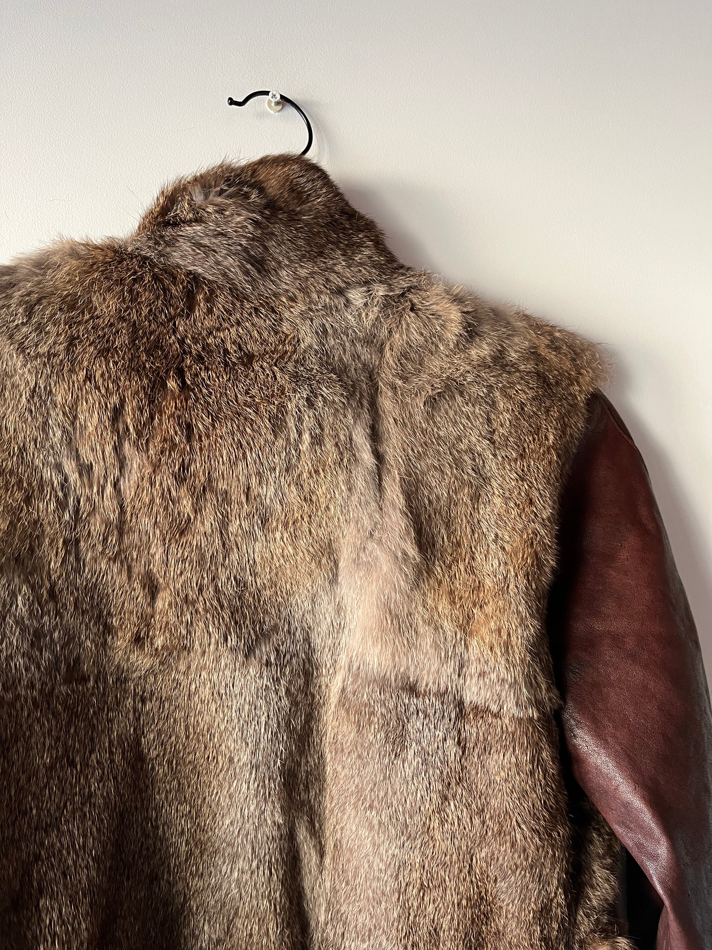 Veste courte en fourrure et cuir à boucles