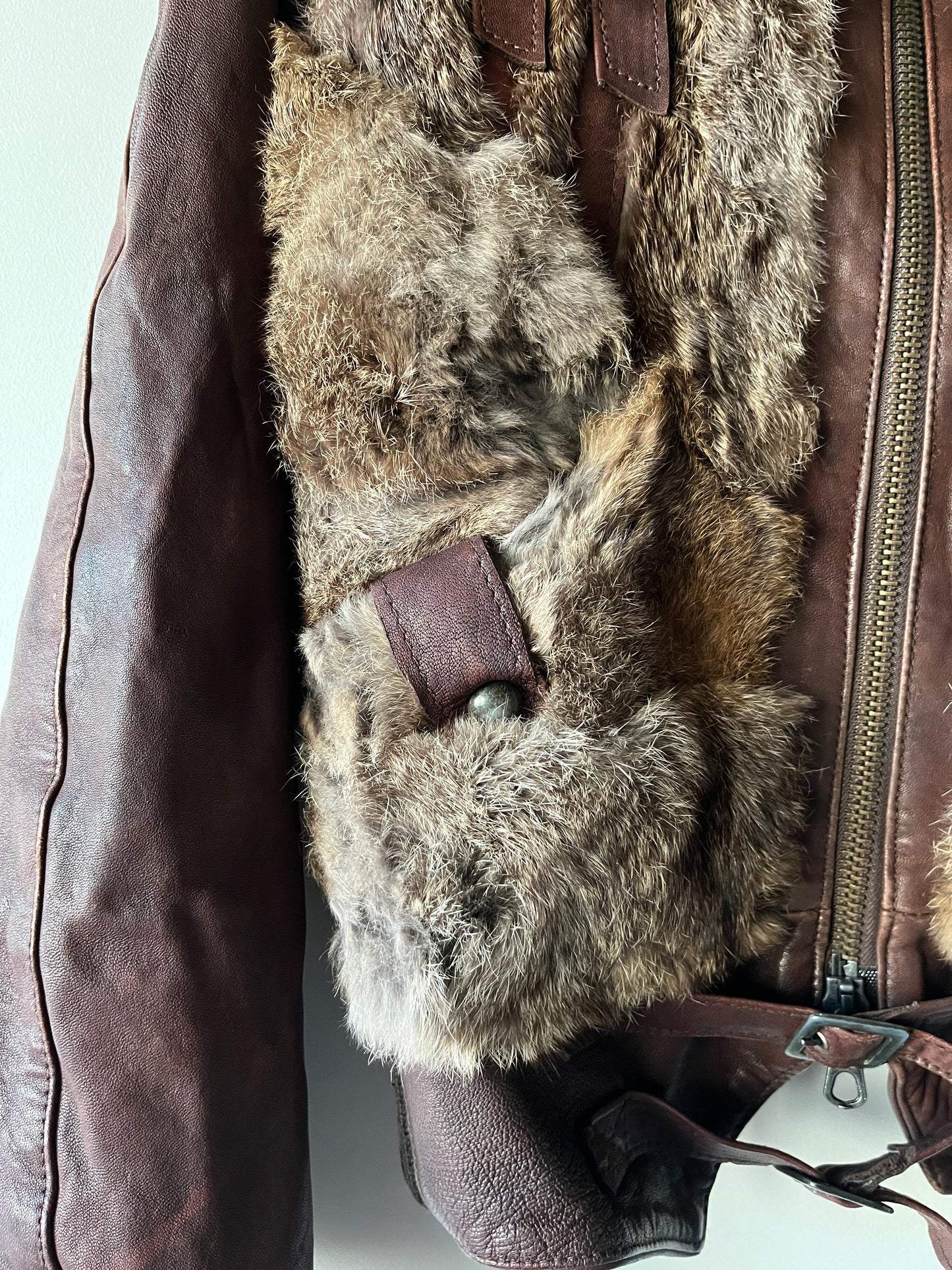 Veste courte en fourrure et cuir à boucles