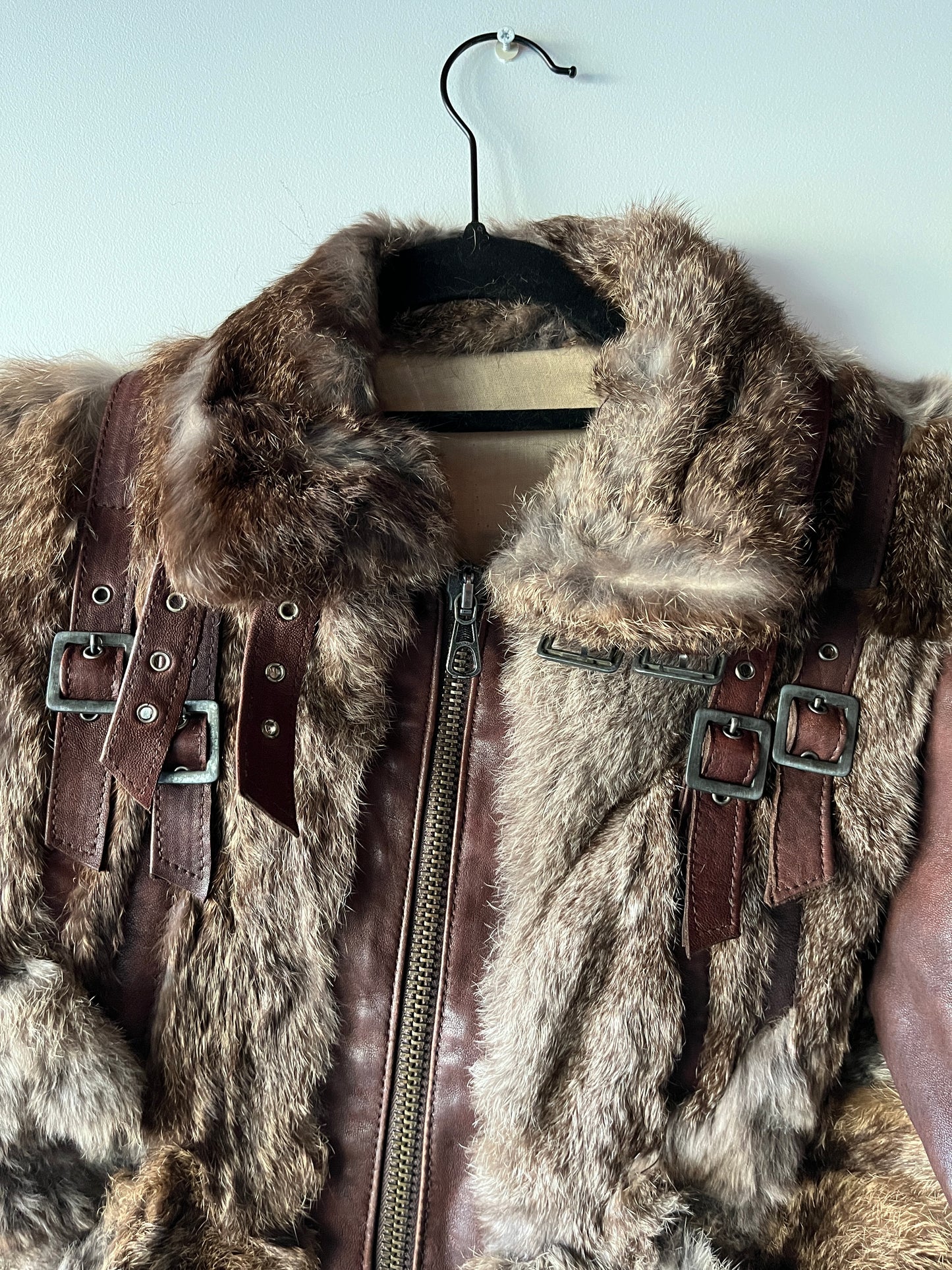 Veste courte en fourrure et cuir à boucles