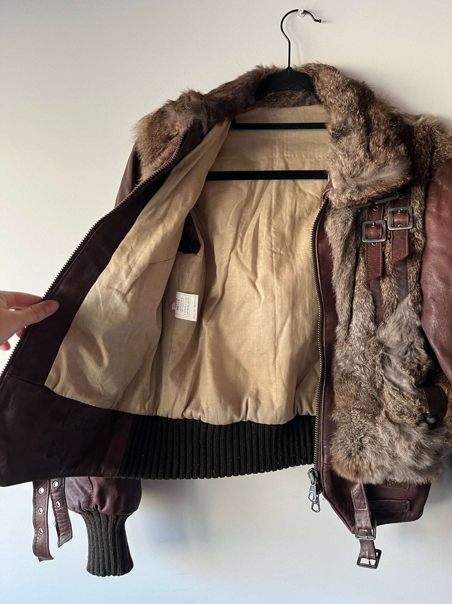 Veste courte en fourrure et cuir à boucles