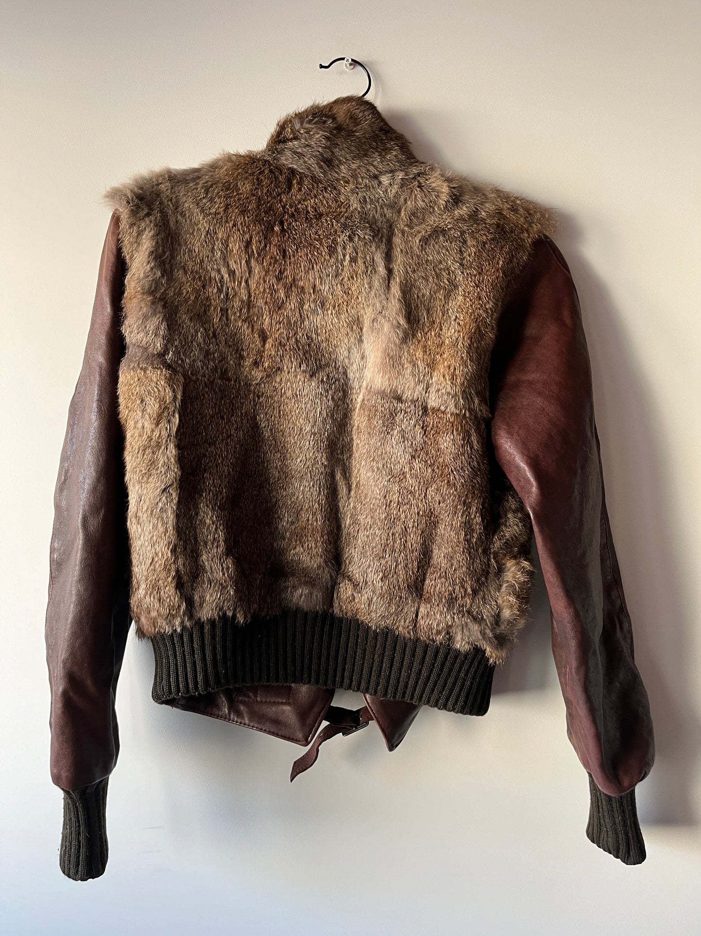 Veste courte en fourrure et cuir à boucles