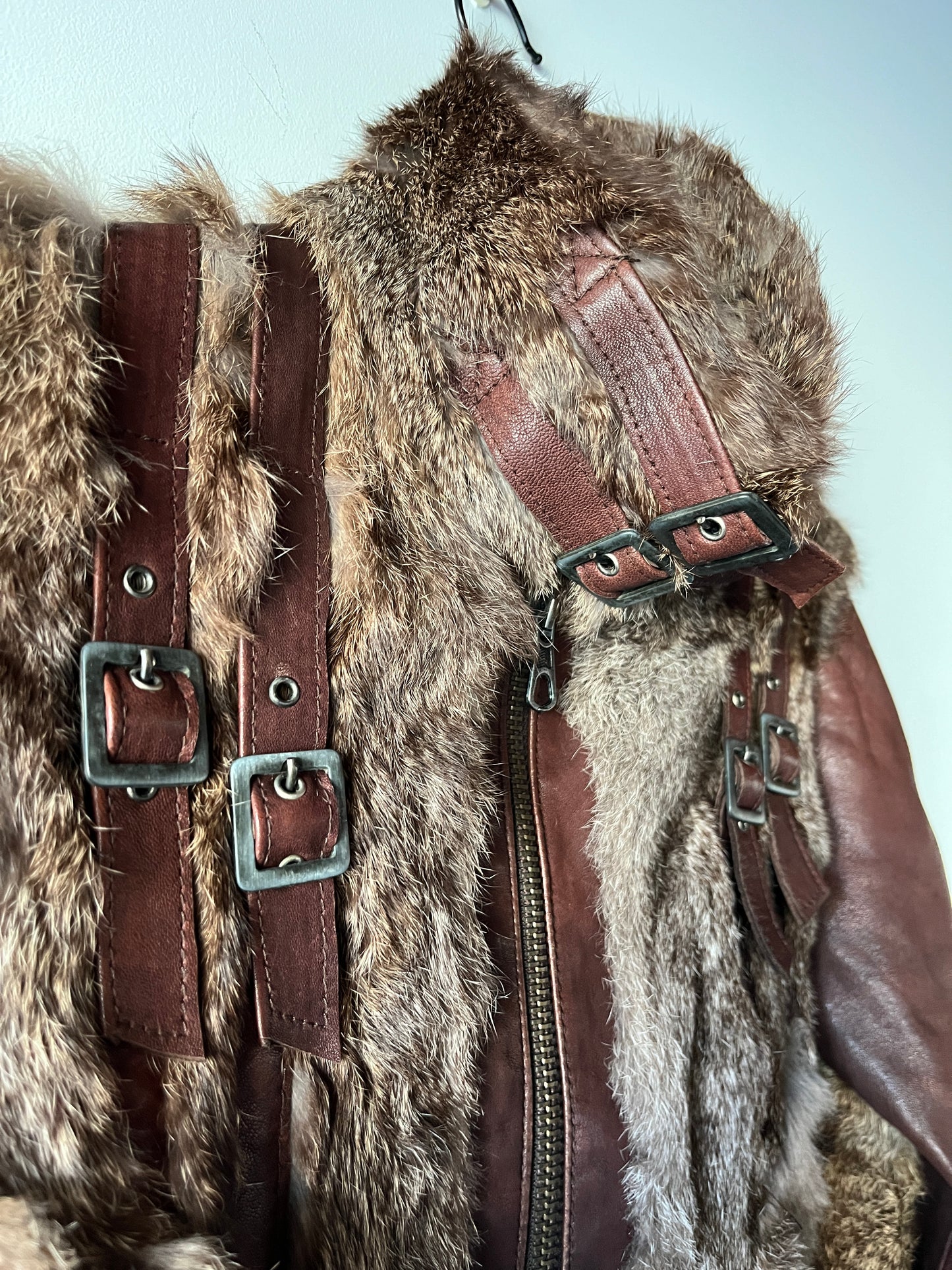 Veste courte en fourrure et cuir à boucles