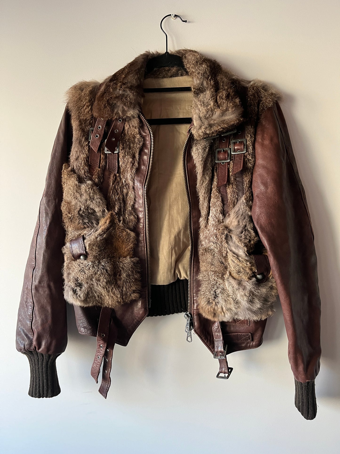 Veste courte en fourrure et cuir à boucles