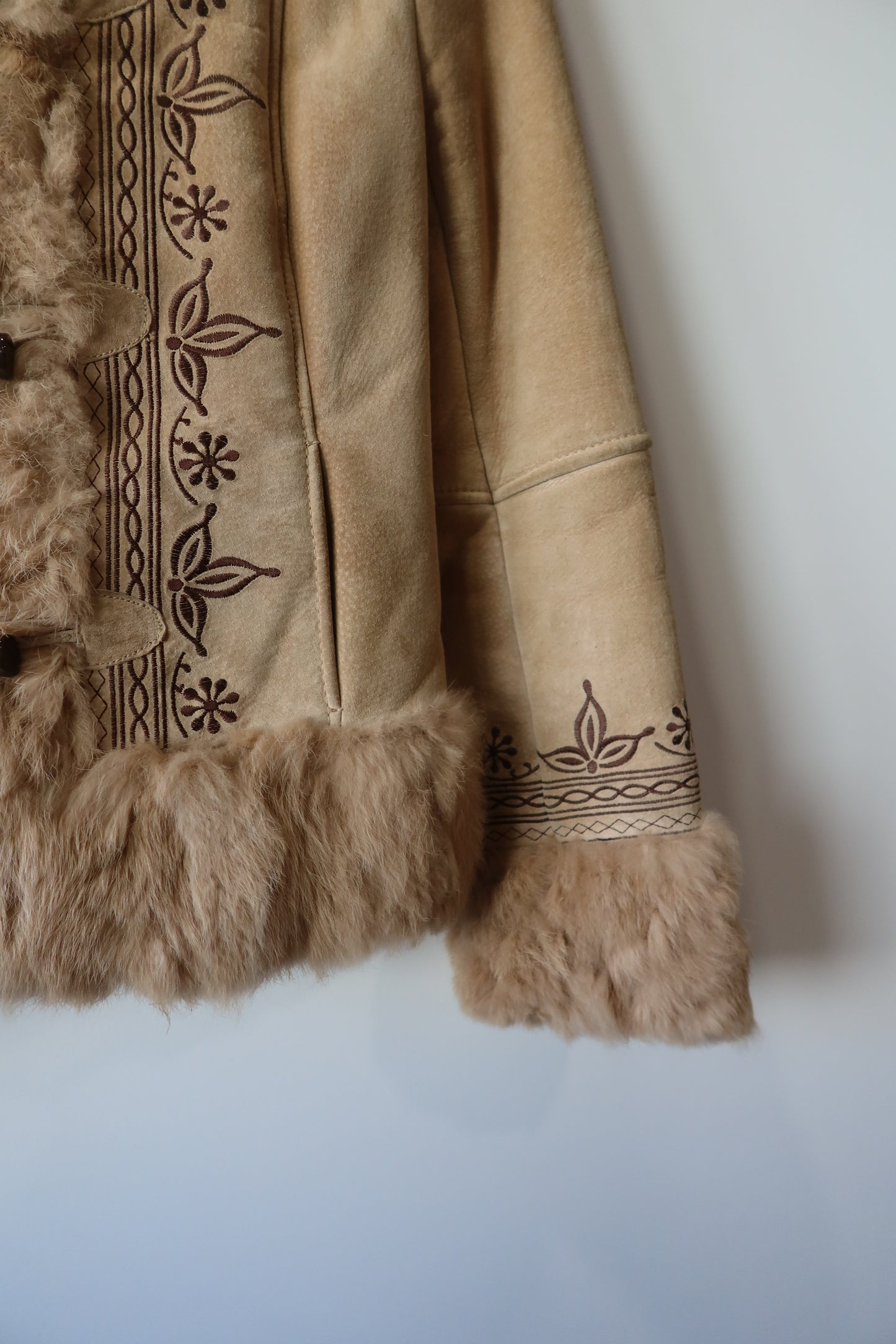 Veste en peau retournée beige et bordures en fourrure