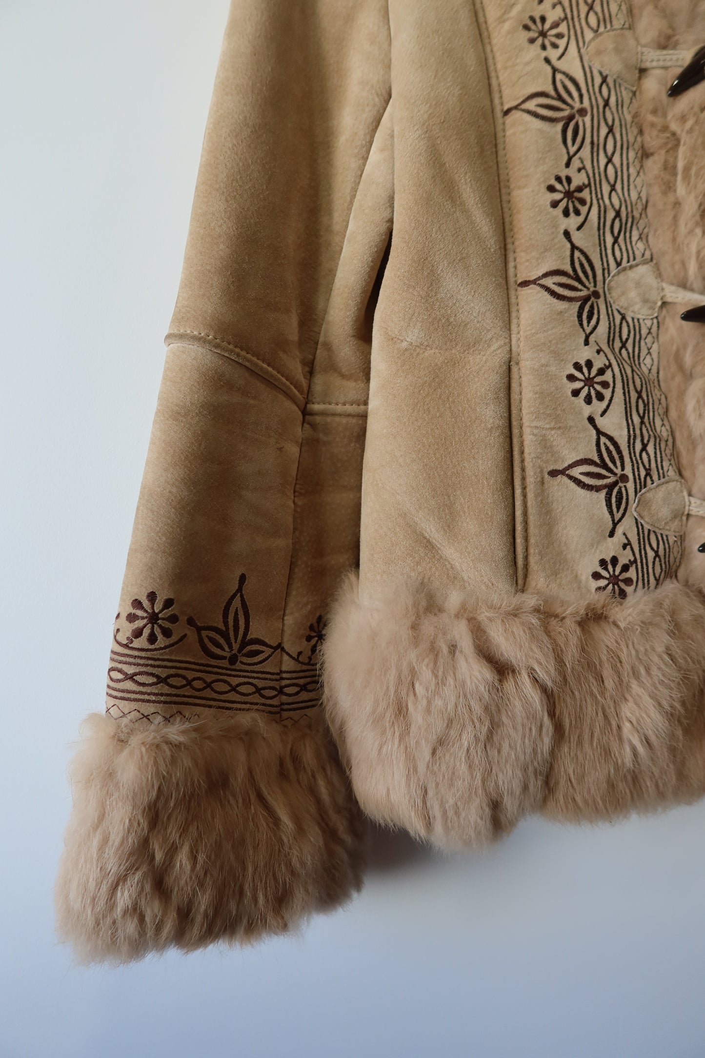 Veste en peau retournée beige et bordures en fourrure