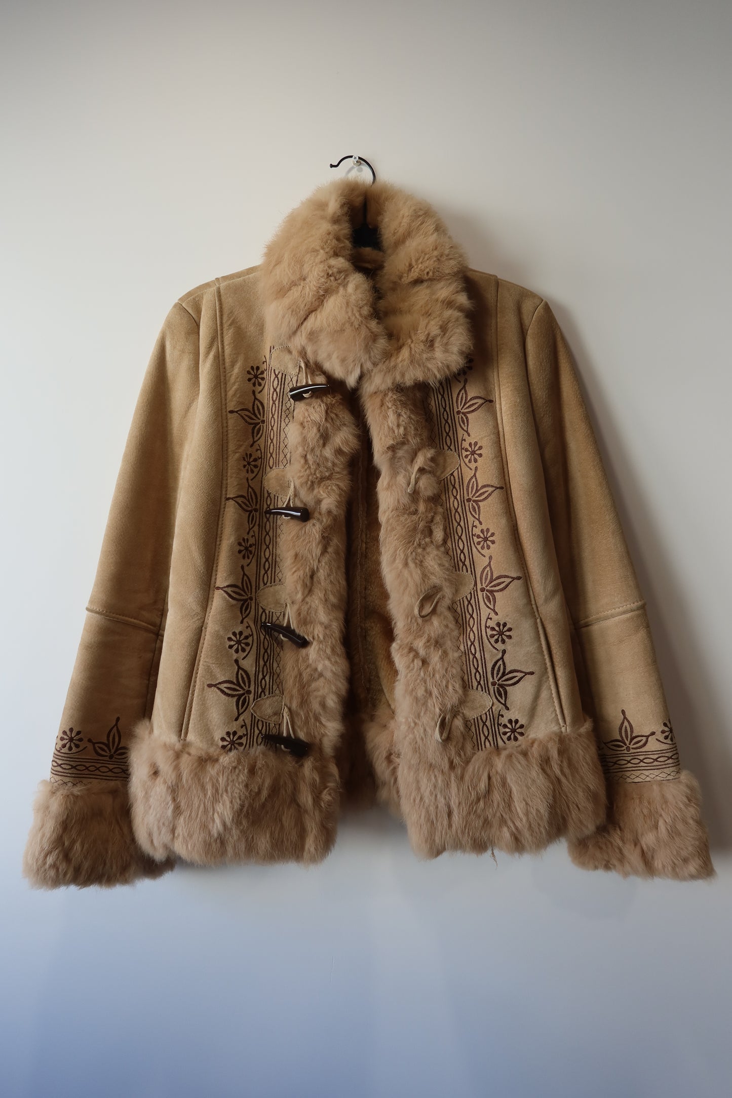 Veste en peau retournée beige et bordures en fourrure