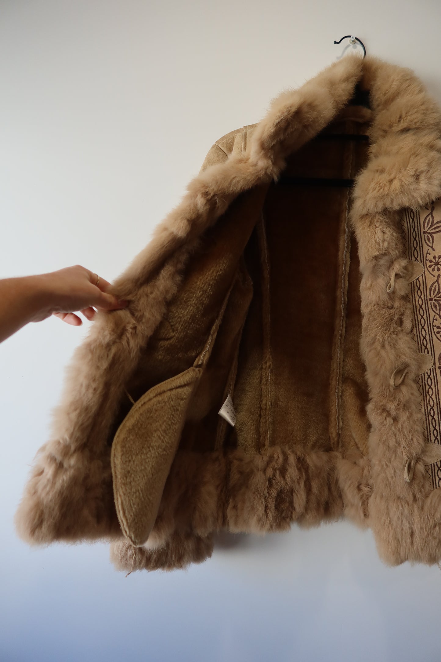 Veste en peau retournée beige et bordures en fourrure