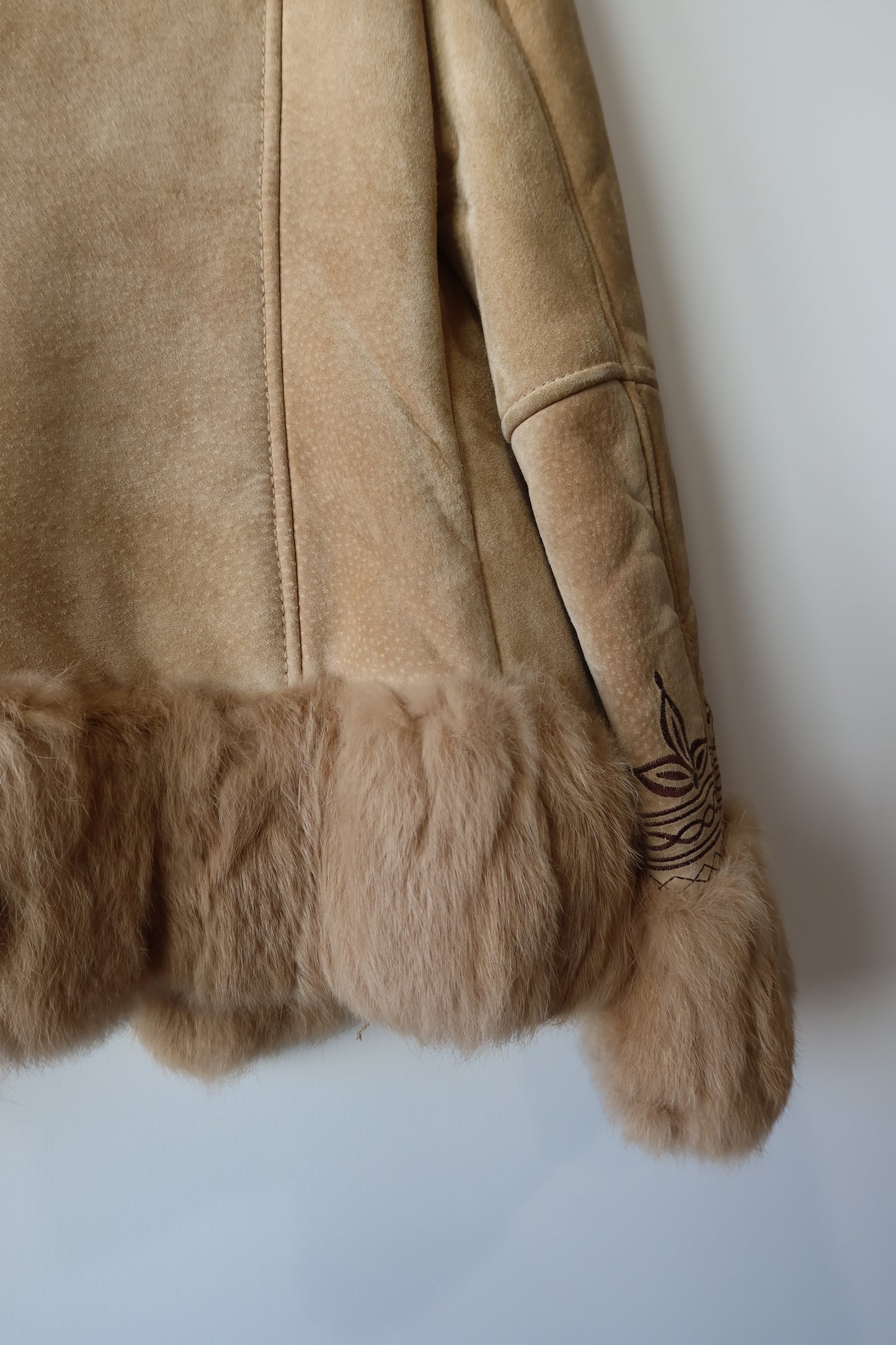 Veste en peau retournée beige et bordures en fourrure