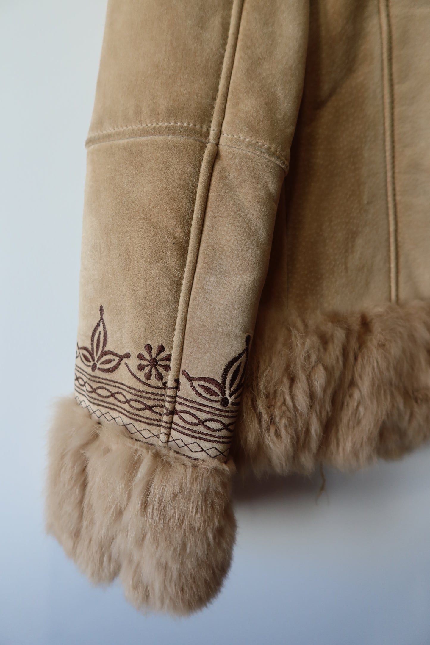 Veste en peau retournée beige et bordures en fourrure