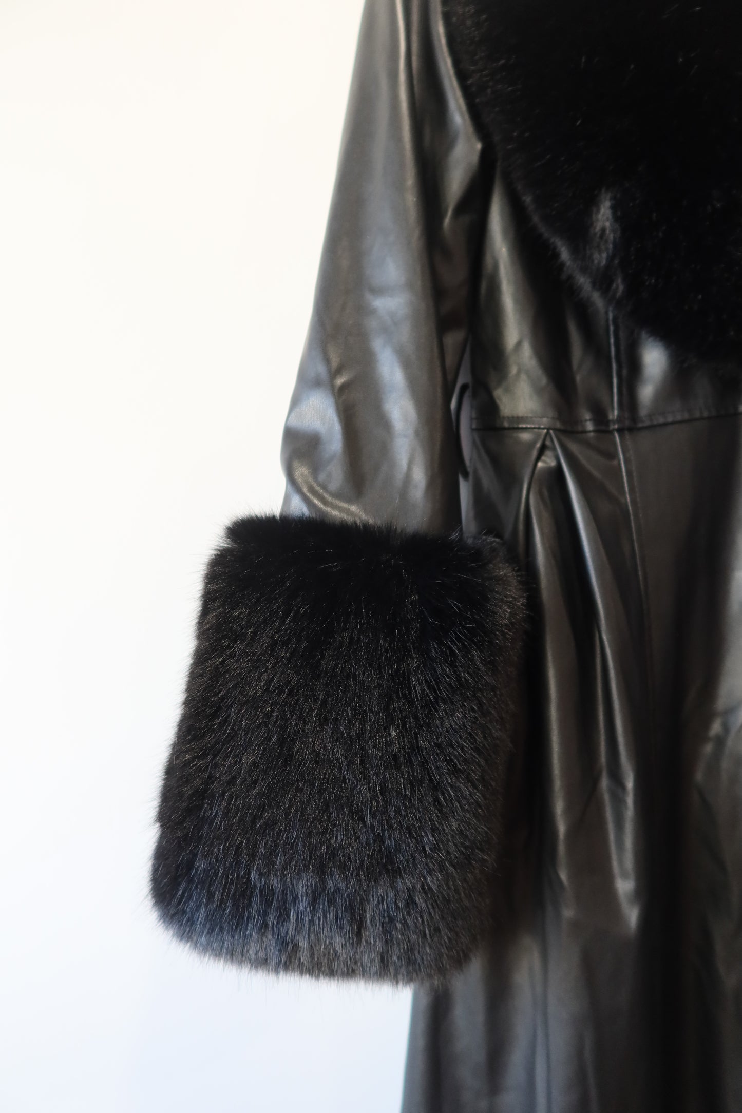 Manteau en simili cuir noir et bordures en fausse fourrure