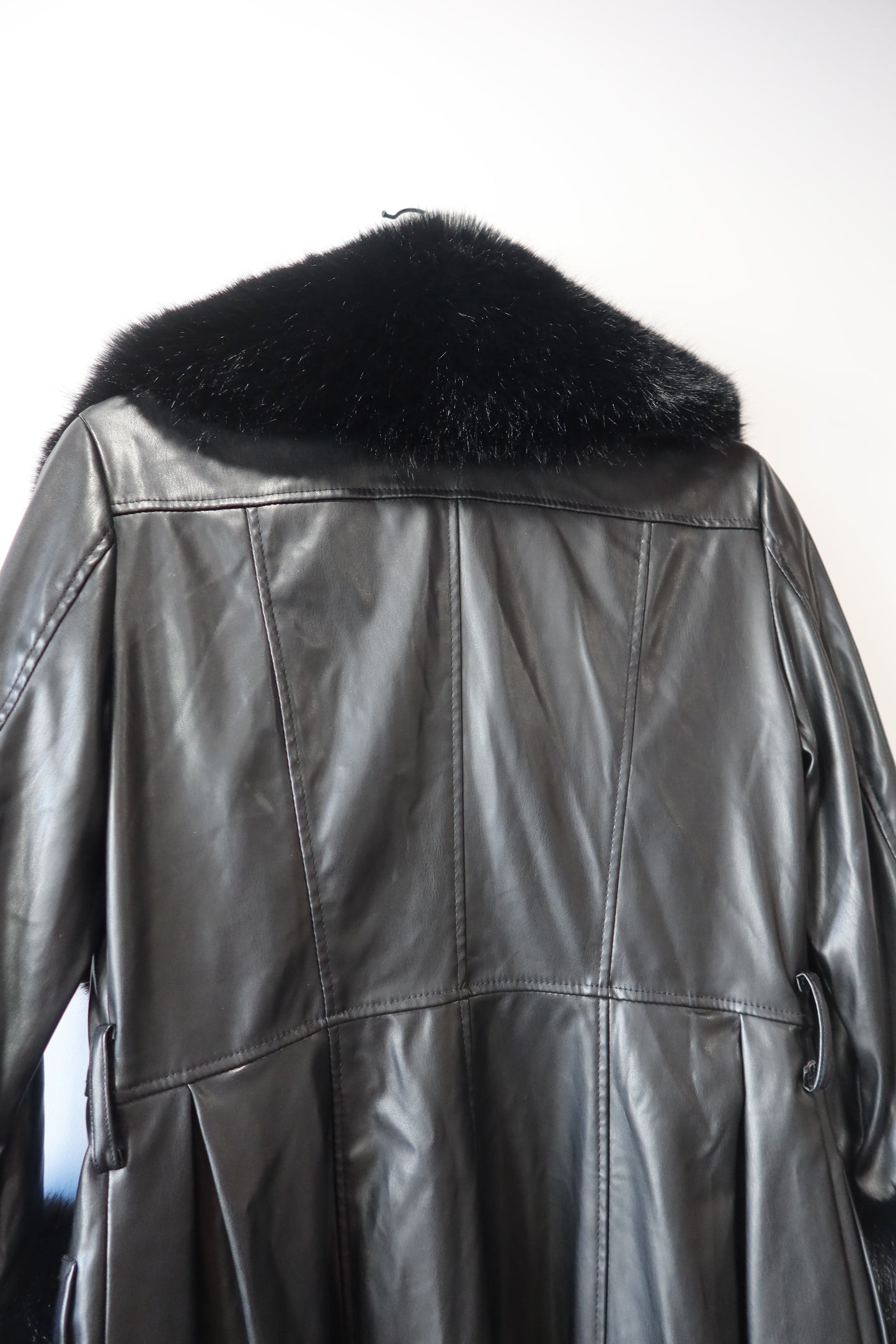Manteau en simili cuir noir et bordures en fausse fourrure