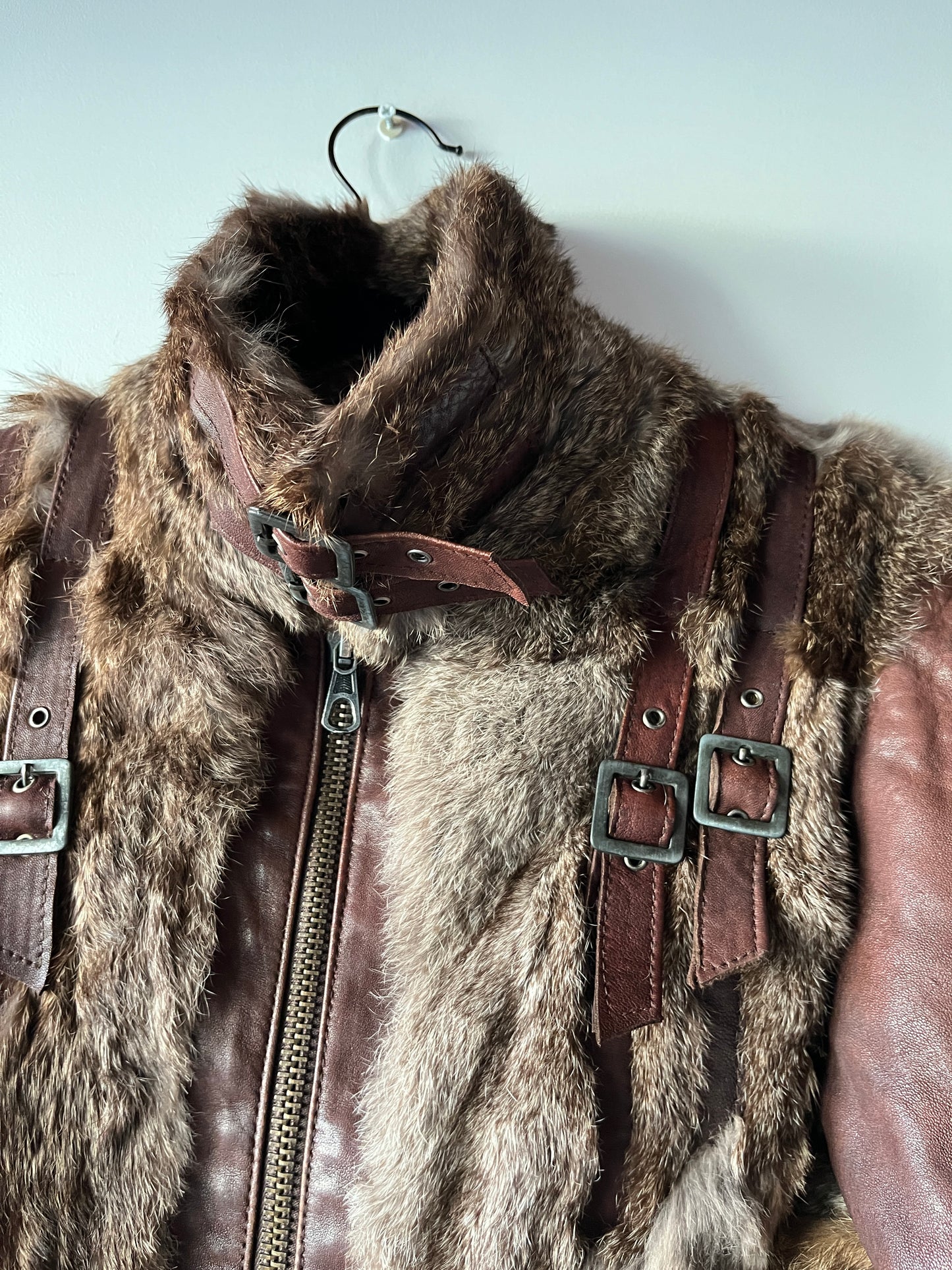 Veste courte en fourrure et cuir à boucles