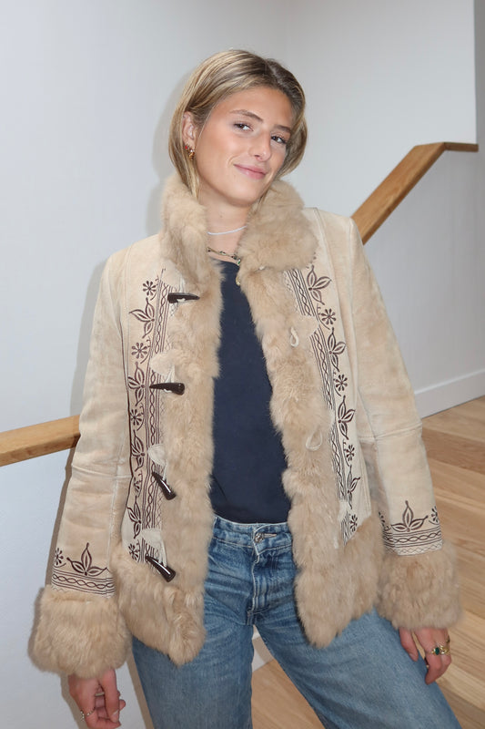 Veste en peau retournée beige et bordures en fourrure