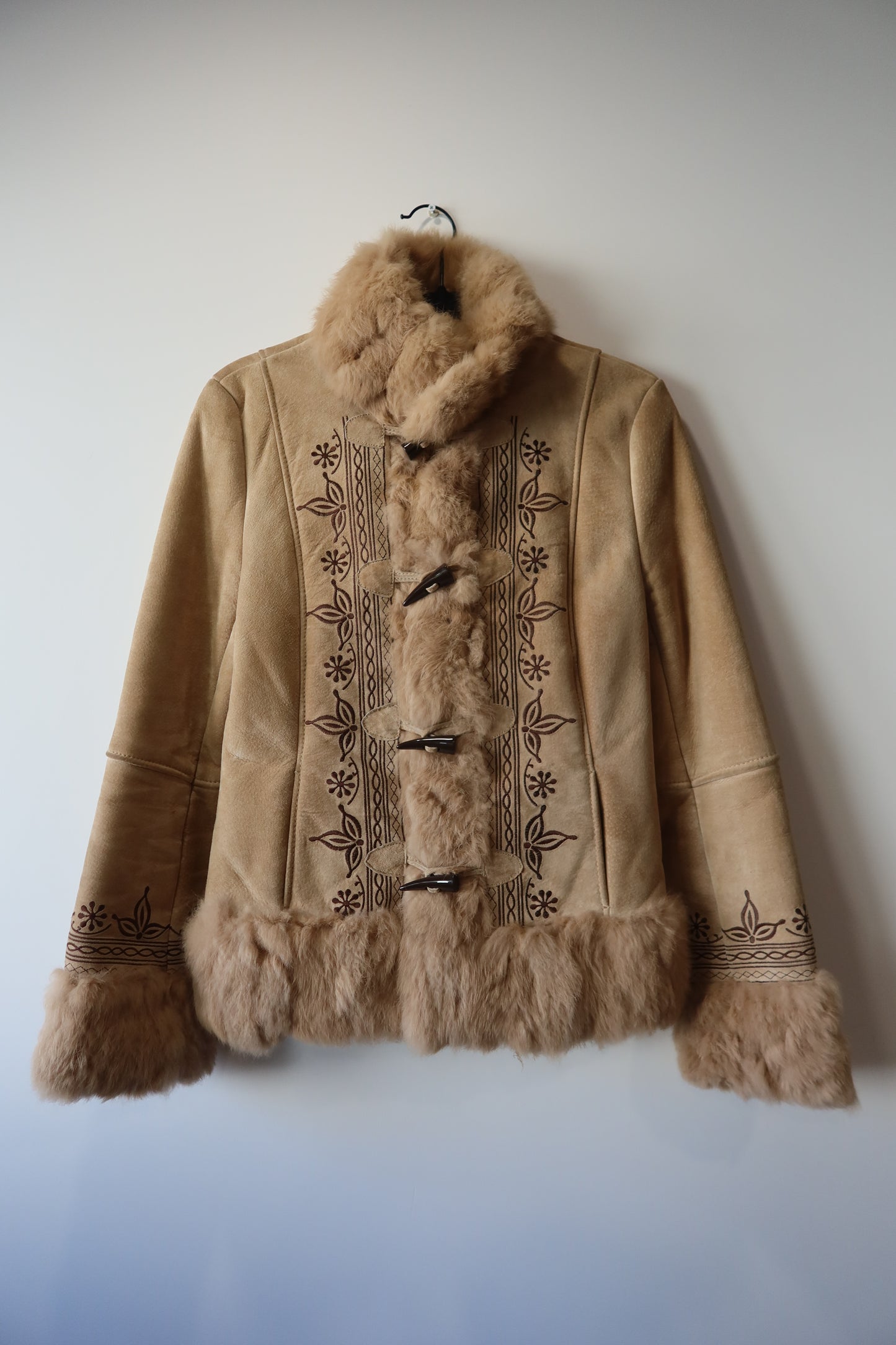 Veste en peau retournée beige et bordures en fourrure