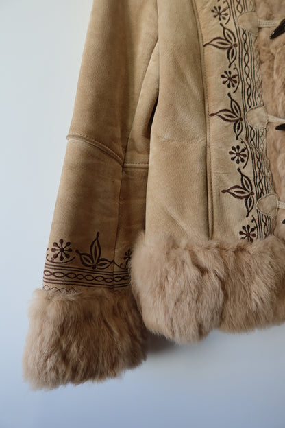 Veste en peau retournée beige et bordures en fourrure