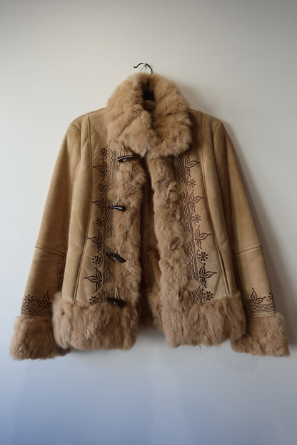 Veste en peau retournée beige et bordures en fourrure